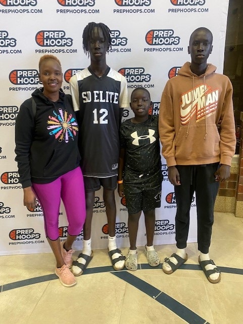 Achut Deng and her three sons stand before a background that reads 