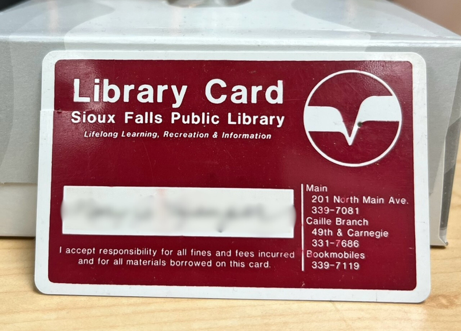 A maroon and white library card that reads 