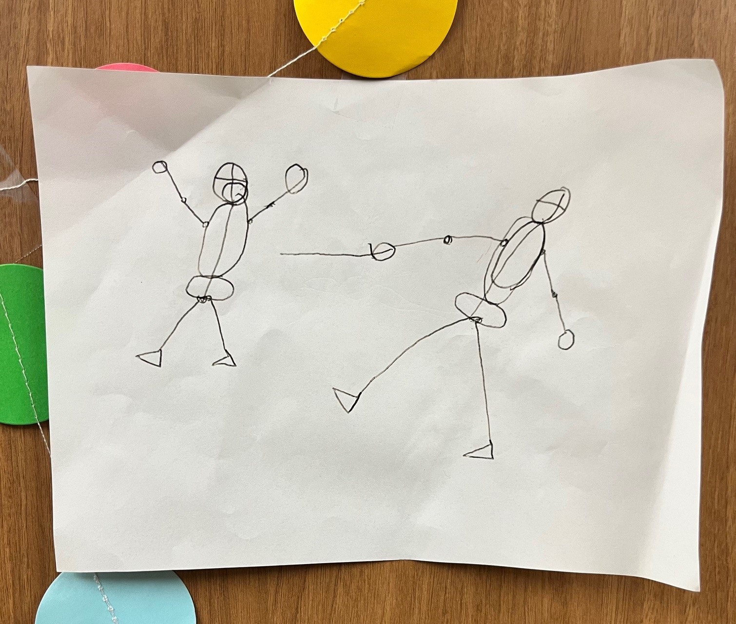 Two human figures made out of lines and rudimentary shapes appear to be fencing.