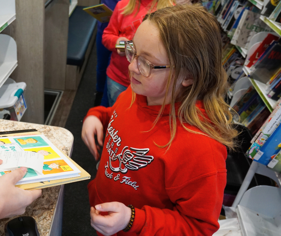 Child checking out books on the bookmobile.